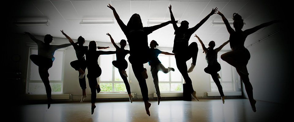 Dansare som hoppar i motljus