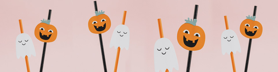 Halloween-pumpor och spöken i papper som sitter på sugrör.