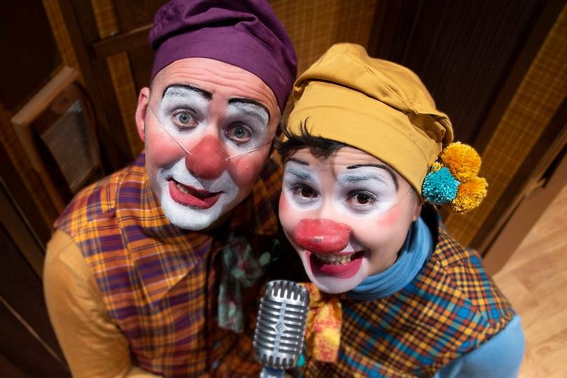 Två blyga clowner bakom en mikrofon