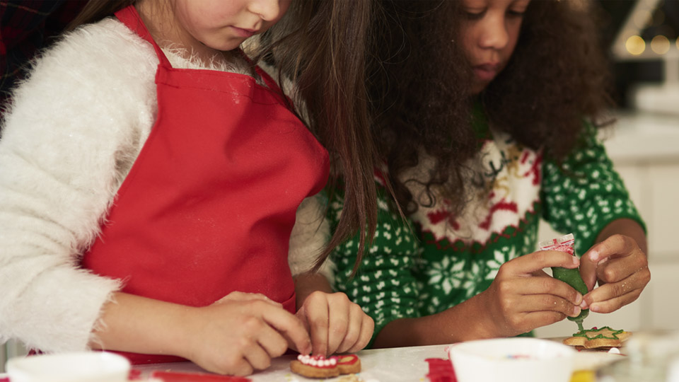 Två barn som dekorerar pepparkakor