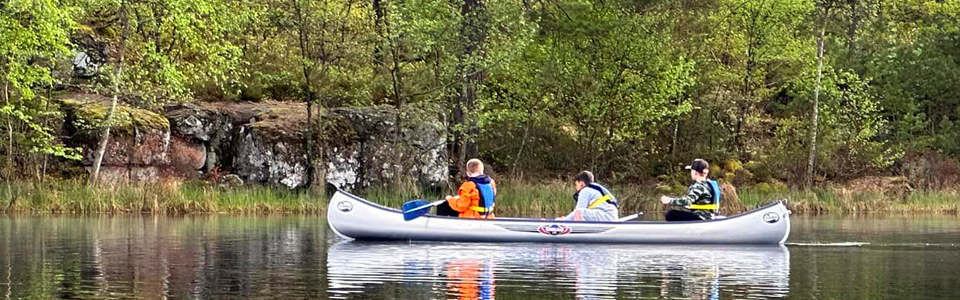 Tre killar i en kanot på sjön Eldmörjan.