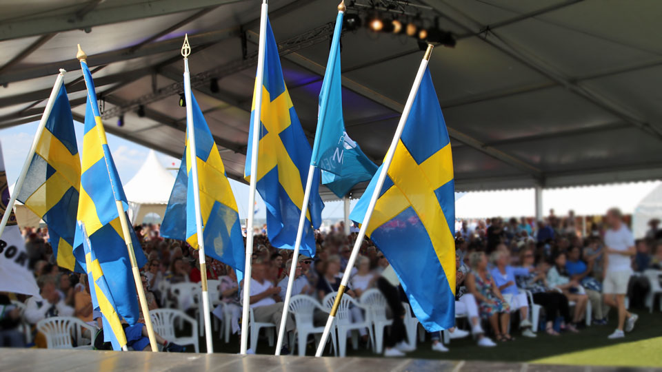 Svenska fanor vid scenen på Vänersborgs nationaldagsfirande på sanden