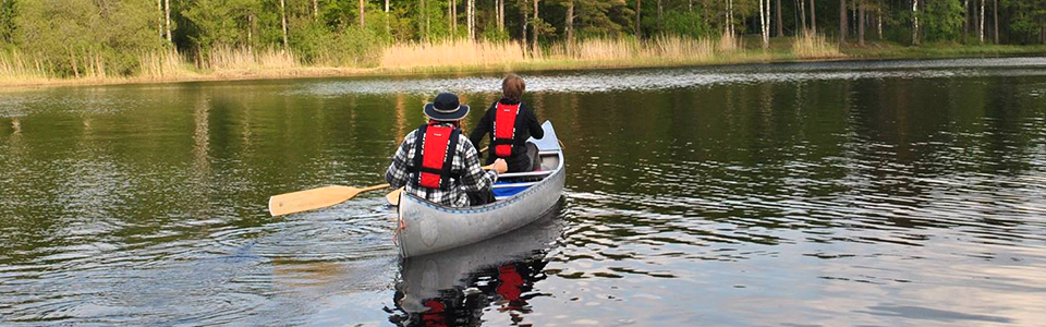 Två personer som paddlar kanot i sjön Eldmörjan på Hunneberg.