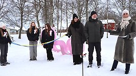 Invigningstal framför den rosa skulpturen i en snöig Centrumpark.