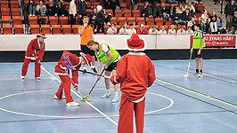 Ungdomar som spelar innebandy. Några är utklädda i tomtedräkter.